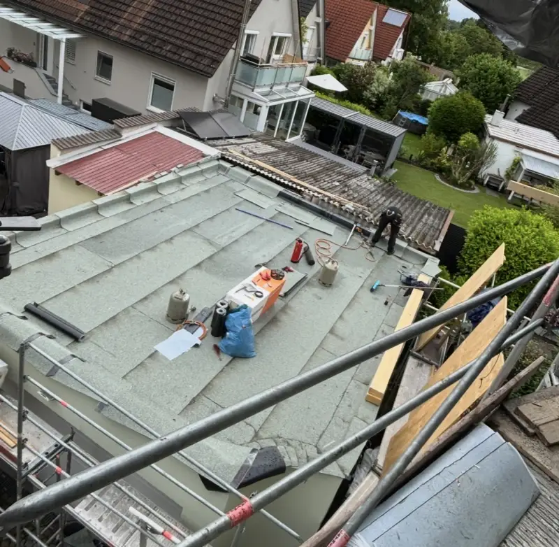 Flachdachfläche mit verlegten Bahnen während der Ausführung