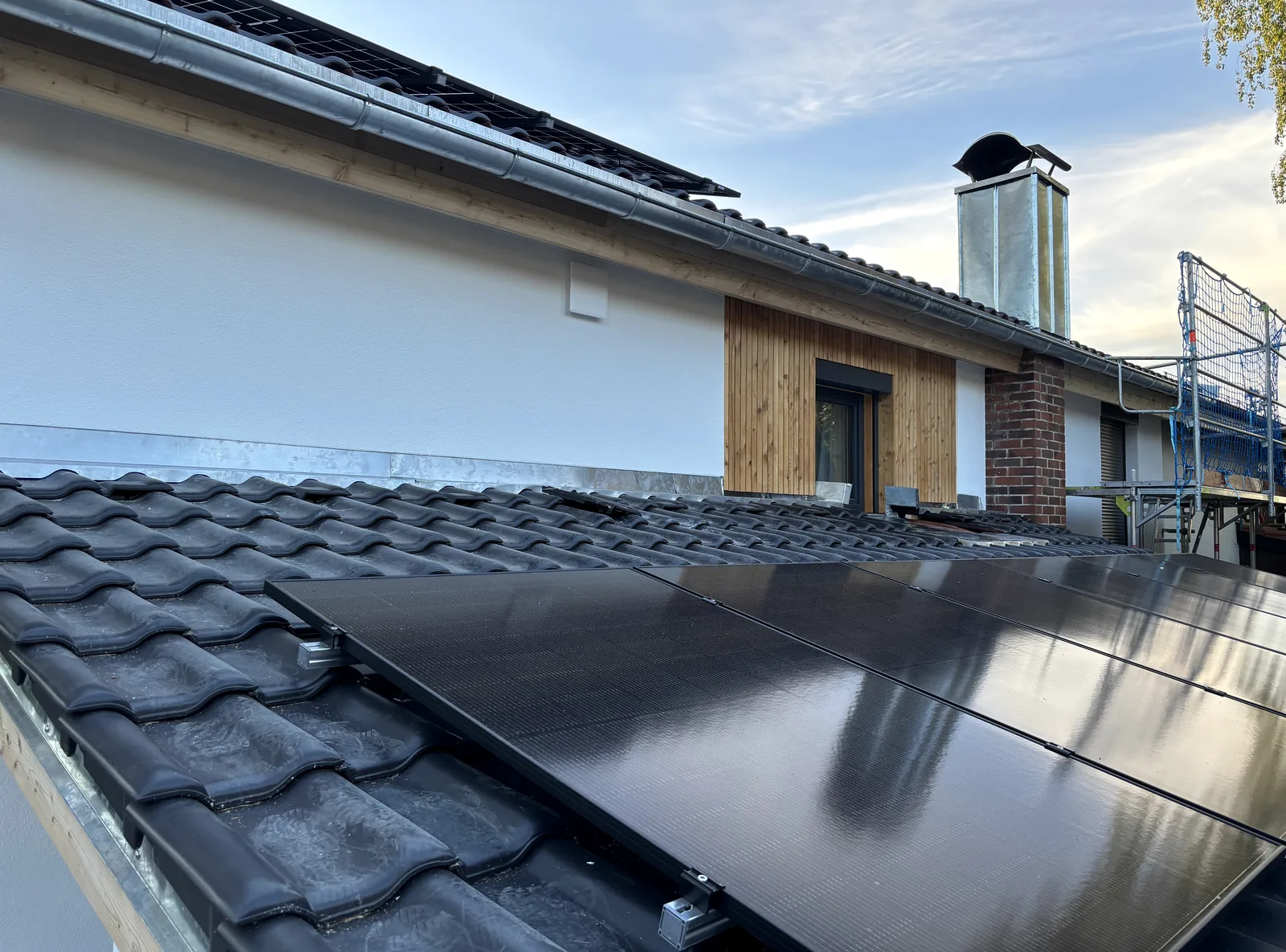 Fertig ausgeführtes Steildach mit PV-Modulen und sauberem Anschlussbereich